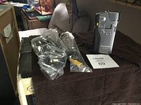 Panasonic KXC-600A video recorder with assorted cables wrapped in plastic on a dark surface.