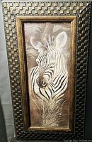 Frontal photo of the framed zebra print showing the artwork and decorative frame pattern in detail.