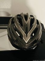 Top-down image showing a black and gray bike helmet with central vent holes and reflective lines on the shell.