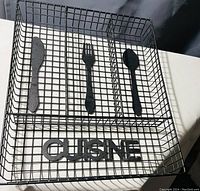 Metal wire cutlery organizer tray with three compartments and decorative metal cutlery silhouettes; 'CUISINE' lettering on front side visible.