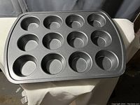 Top angle photo showing entire 12-cup muffin tin on cloth surface in a neutral setting