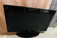 Front view of the Samsung 32-inch TV showing the screen and the base stand.