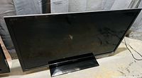 Front view of black Sony 42-inch BRAVIA flat screen TV in standby or off state, with reflection visible on screen.