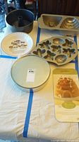 Photo showing all baking items together on a table: springform tube pan, pecan pie plate, round cake pan, and gold-colored cake mold with various shapes.