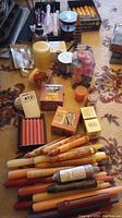 Overview photo showing many candle types including boxed Colonial Candle set, pillar candles, votives, and loose tapers in multiple colors.