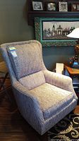 Full view of high back upholstered chair, showing textured grey fabric, padded arms, and tall winged backrest.