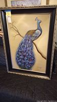 Full view of the framed artwork showing the peacock on the branch and the ornate frame
