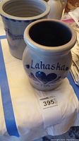 Photo of two tan pottery vases, one shorter with blue floral design and 'Lahaska' wording, the other taller with blue flower design.