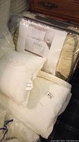 Photo showing Grand Estate 1000 thread count sheet set packaging and pillows in front