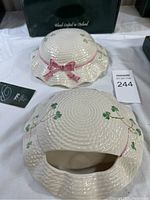 Top view showing the textured porcelain bonnet shape with pink bow and shamrocks on each vase, including auction tag visible.