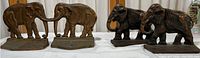 Two sets of brass elephant bookends shown side by side, displaying different elephant poses.