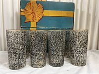 Full grouping of 8 vintage Libby Riviera speckled black glasses with original damaged box in background