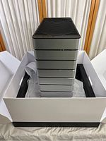 Front view of the silver Abee Smart Desktop Tower in packaging, showing black vented top and segmented front panels.