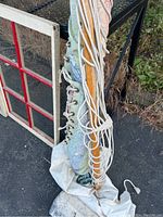 Photo showing hammock rolled up, with wooden spreader bars and colorful fabric edges with rope ties.