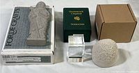 Full lot including stone figurine, crystal cube, stone egg, and original packaging boxes arranged on white surface.