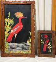 Full view of both Mexican feather bird artworks with carved wood frames showing size difference and style.