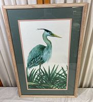 Framed bird print in light wood frame, showing full image of a blue heron among foliage.