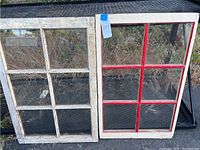 Two vintage window panes side by side, one white and one white with red muntins, both with six glass sections.