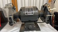 Full front view of the vintage Coast electric bench grinder with two grinding wheels and safety shields.