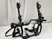 Wide shot of the black metal Hollywood bike rack featuring an adjustable frame and securing straps.