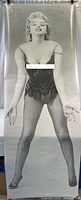 Full front view of the life-sized Marilyn Monroe poster, showing her standing pose with fringe corset and fishnet stockings.