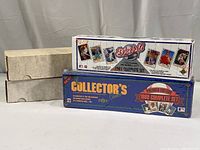Four boxes of baseball cards with two white boxes and two color-branded boxes stacked, one branded 'Collector's Choice' and the other 'Baseball 1991 Edition'