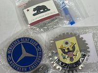Photo showing the three medallions: California Republic bear flag, U.S.A. eagle on gear backing, and Mercedes-Benz Club Northern California.