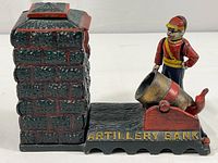 Side view showing soldier figure standing beside painted cannon with 'ARTILLERY BANK' text on base, showing brick wall detail.