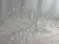 View of all 12 clear champagne flutes lined up showing their shape and size.