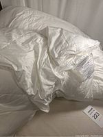 Photo showing the full white duvet insert lying on a bed with visible label.