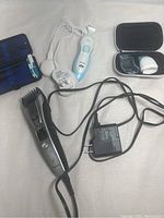 Both Panasonic hair clipper and Philips bikini trimmer with chargers displayed together.