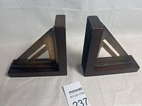 Pair of dark wood base book ends with metal ruler design triangular inserts, front view.