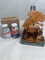 Photo showing six wooden koala-shaped coasters with Aboriginal style dot paintings and a wooden holder with 'Hand Made' text. Ceramic salt and pepper shakers with Australia themed designs and a cardboard box labeled 'Australia' are also shown.