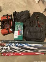 Wide layout of the lot with backpacks, water belt with drink holders, boxed golfers drink caddy, and golf umbrellas.
