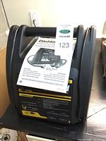 Front view of DieHard portable power unit with model number and manual attached.