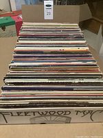 Photo of one side of the box containing a large collection of assorted LP records with Fleetwood Mac album cover visible on the box side.
