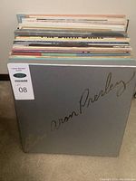 Stack of vinyl album covers seen from front, showing grey Elvis Aron Presley slipcase