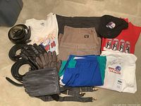 Assortment of men's clothing including shorts, T-shirts, belts, gloves, and ball cap.