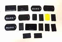 18 G.I. JOE display stands and accessories laid out on a white background. Includes dog tags marked MARS, foot pads, rectangular bases with logos, and connectors.