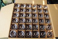 Top-down view showing 36 wine glasses packed in individual slots inside an open cardboard box.