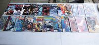 Full view of all 21 comic books lined up flat in two rows showing covers.