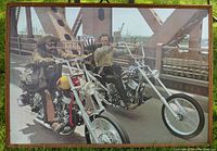 Framed photo showing two men on motorcycles on a bridge with distinct choppers and rider attire.