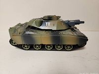 Side view of the motorized G.I. JOE Mobat Battle Tank showing camouflage paint and track details.