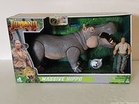 Front view of Massive Hippo toy in original box with human figure accessory and Jumanji branding.