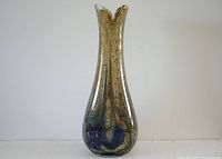 Front view of the vase showing its tapered shape and swirling multicolored design with brown, blue and green tones.