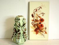 Photo showing carved green candle with curled cut style alongside framed dried flower art