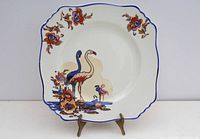Front view of square ceramic plate with Art Deco flamingo design in red, blue, and brown colors.