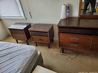 Overall view of wood veneer dresser with attached mirror and two matching nightstands