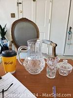 Photo showing small crystal pitcher, cream and sugar containers, and toothpick holder arranged on a table with a McCafe cup nearby for size reference.