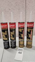 Four tubes of Lepage PL Construction Adhesive standing upright, showing labels and nozzles